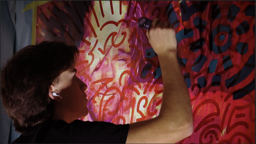 Picture of aidan painting over a picture of Kurt Cobain